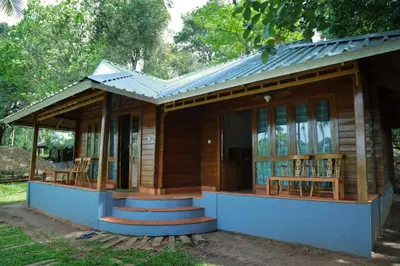a small wooden house with a porch and stairs at Royal Wooden villa in Mananthavady