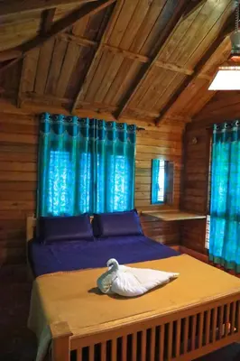 a room with a bed with a swan on it at Royal Wooden villa in Mananthavady