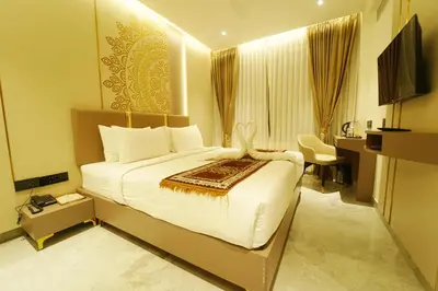 a hotel room with a large bed and a desk at Yuvraj Le: Royale in Mysore