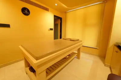 a bathroom with a sink in a room with yellow walls at Yuvraj Le: Royale in Mysore