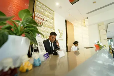 a man talking on a cell phone at a counter at Yuvraj Le: Royale in Mysore