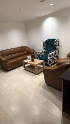 a living room with a couch and a chair and a table at Yuvraj Le: Royale in Mysore
