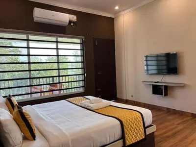 a bedroom with a bed and a large window at Coorg Le Embera in Virajpet