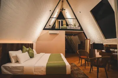 a bedroom with a bed with a staircase in the background at Inika in Ponnampet