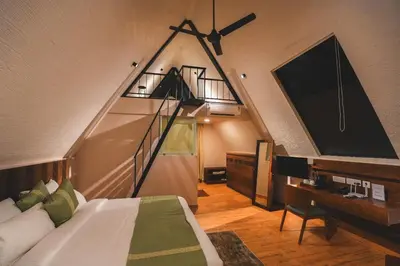 a bedroom with a bed and a tv in a room at Inika in Ponnampet