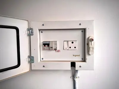a white electrical outlet on a wall with a plug at Happy Villa Homestay in Chelakara