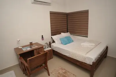 a bedroom with a bed and a desk with a telephone at Happy Villa Homestay in Chelakara