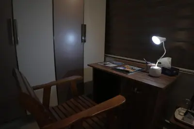 a desk with a lamp and a chair in a room at Happy Villa Homestay in Chelakara