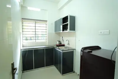 a kitchen with black cabinets and a sink at Greens in Kozhikode