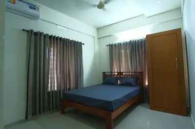 a small bedroom with a bed and a window at Greens in Kozhikode