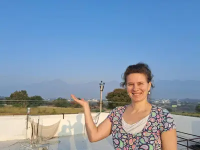 a woman standing on a roof with her hand in the air at ARUL Residency in Mettuppālaiyam