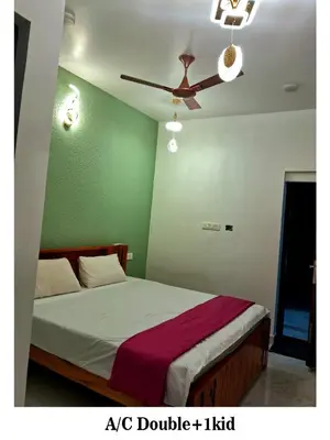 a bedroom with a bed with a ceiling fan at ARUL Residency in Mettuppālaiyam