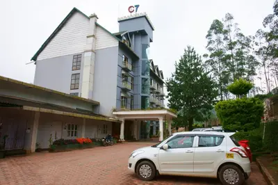 a white car parked in front of a building at Hotel C7 Munnar in Munnar
