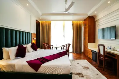 a bedroom with a large bed and a kitchen at Hotel C7 Munnar in Munnar
