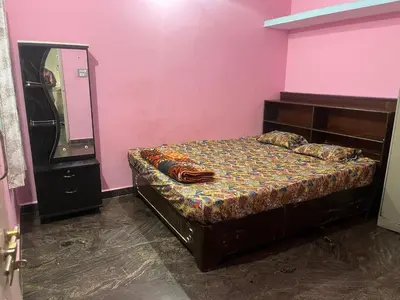 a bedroom with a bed and a dresser and a mirror at Dreamy bungalow 2BHK apartment in Mysore