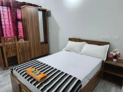 a bedroom with a bed with a towel on it at GREEN FIELDS Apartments in Mananthavady