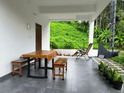 a wooden table and a bench on a patio at GREEN FIELDS Apartments in Mananthavady