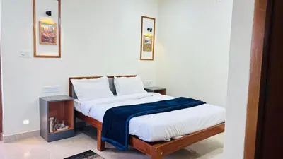 a bedroom with a bed with a blue blanket on it at Hidden doors in Ooty