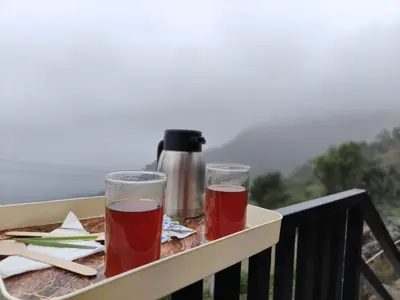 two glasses of beer are sitting on a balcony at Royal Adventures in Kodaikānāl