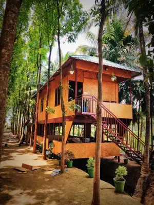 a house in the middle of a forest with trees at Thanima Farmlife experiential Farm Tourism in Nallepilli