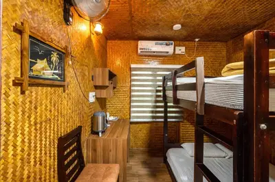 a room with two bunk beds and a table and a desk at Thanima Farmlife experiential Farm Tourism in Nallepilli