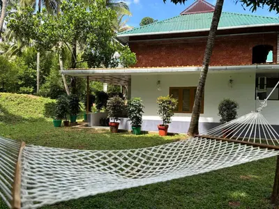 a hammock in front of a house at Thanima Farmlife experiential Farm Tourism in Nallepilli