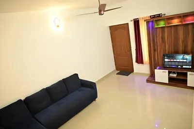 a living room with a couch and a tv at Geetham Villas in Palakkad