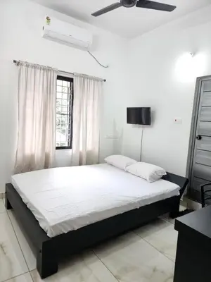 a bedroom with a bed and a ceiling fan at Olive Home stay Gold 1bhk in Alwaye