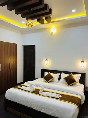 a bedroom with a large bed with yellow lighting at Windgram Homestay in Ambalavayal