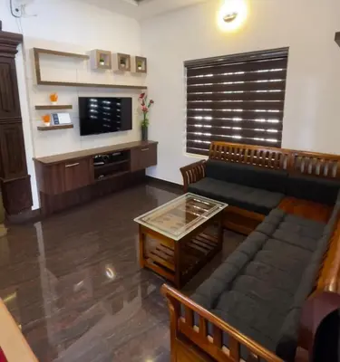 a living room with a couch and a table at Windgram Homestay in Ambalavayal