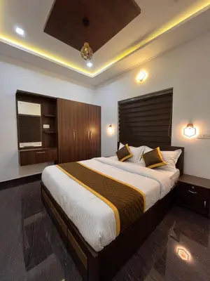 a bedroom with a large bed with a wooden headboard at Windgram Homestay in Ambalavayal