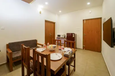 a kitchen and dining room with a wooden table and chairs at Grand Plaza Inn in Kottakkal