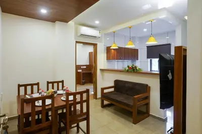 a kitchen and living room with a table and chairs at Grand Plaza Inn in Kottakkal