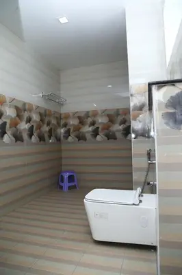 a bathroom with a toilet and a purple stool at Sri Ranga Nivas in Palani