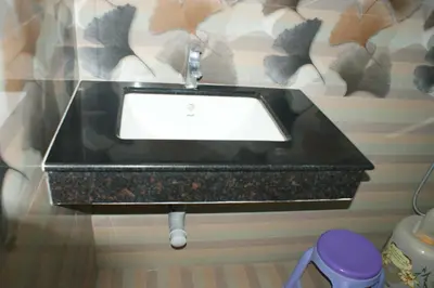 a bathroom with a black sink with a window at Sri Ranga Nivas in Palani