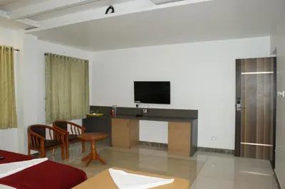 a room with a bed and a tv on a wall at Sri Ranga Nivas in Palani