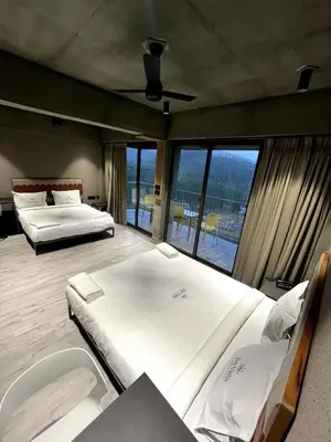 two beds in a room with large windows at BEL VISTO in Vālpārai