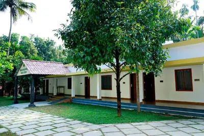 a house with a tree in front of it at Nisarga Ayurveda in Kizhake Chālakudi