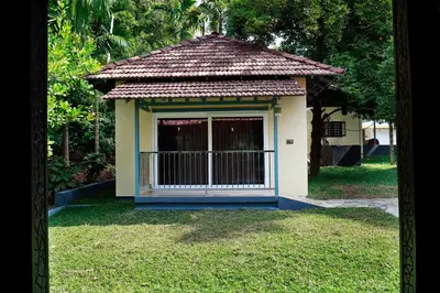 a small building with a gate in the grass at Nisarga Ayurveda in Kizhake Chālakudi
