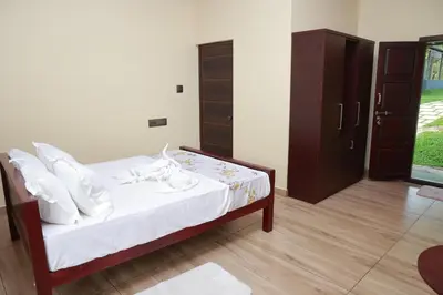 a bedroom with a bed with white sheets and white pillows at Nisarga Ayurveda in Kizhake Chālakudi