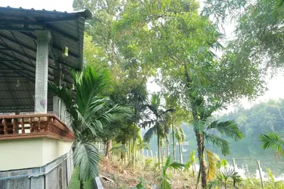a house with a view of a hill and trees at Nisarga Ayurveda in Kizhake Chālakudi