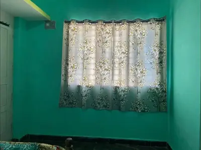 a blue wall with a curtain with trees on it at Roof top couple stay cozy in Mysore