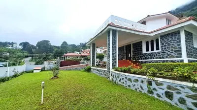 a house with a green lawn in front of it at iSTAYS - Kodai Villa in Kodaikānāl