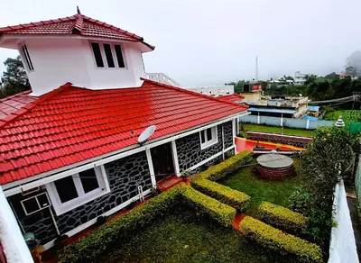 a house with a red roof with a yard at iSTAYS - Kodai Villa in Kodaikānāl