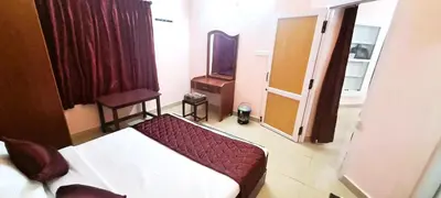 a hotel room with a bed and a mirror at iSTAYS - Kodai Villa in Kodaikānāl