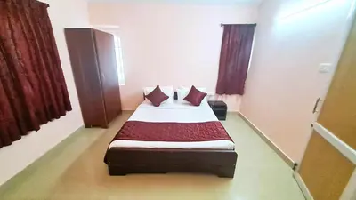 a bedroom with a bed with pillows on it at iSTAYS - Kodai Villa in Kodaikānāl