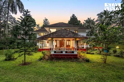 a house with a large yard with a house at StayVista at Wellbeing Villa in Wayanad