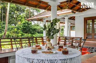 a table with food and drinks on a patio at StayVista at Wellbeing Villa in Wayanad