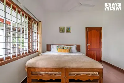 a bedroom with a bed in a room with windows at StayVista at Wellbeing Villa in Wayanad