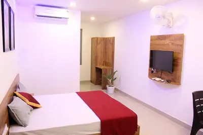 a bedroom with a bed and a tv on the wall at Queen C Inn Wayanad in Mānantoddy